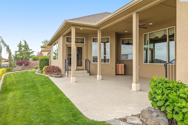 back of house featuring a lawn, stucco siding, and a patio