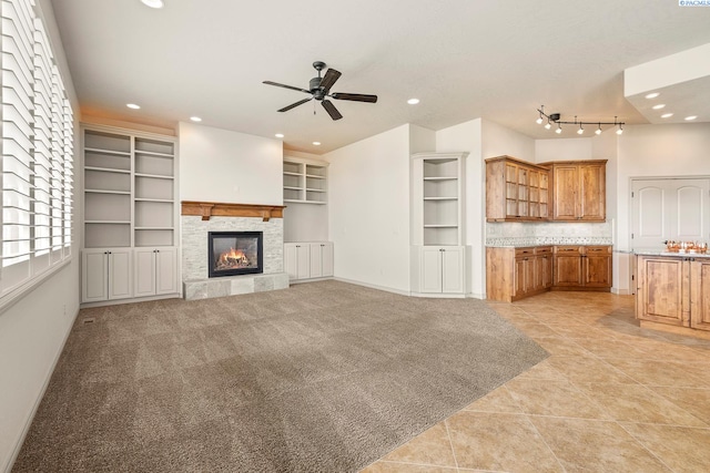 unfurnished living room with ceiling fan, a fireplace, and recessed lighting