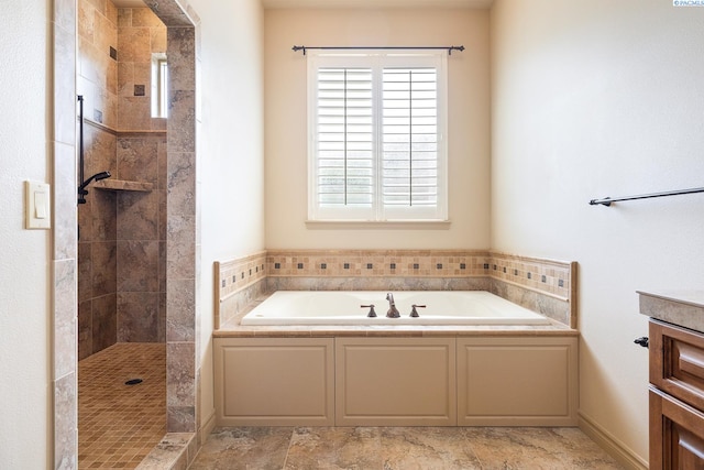 bathroom with vanity, a tile shower, and a garden tub
