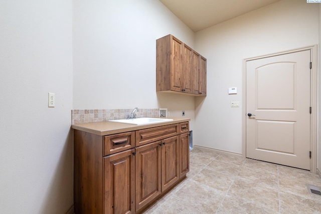 clothes washing area featuring cabinet space, electric dryer hookup, a sink, and hookup for a washing machine