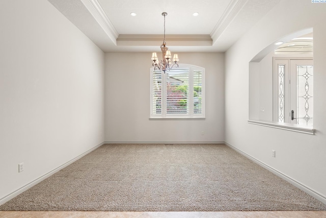 unfurnished room with crown molding, an inviting chandelier, carpet floors, and a raised ceiling