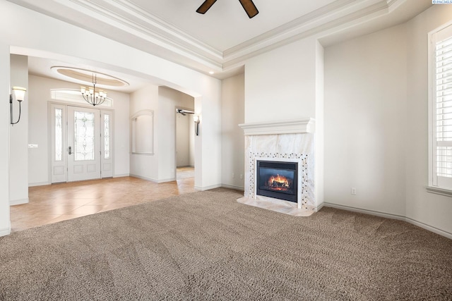 unfurnished living room with arched walkways, a tiled fireplace, plenty of natural light, carpet, and ornamental molding