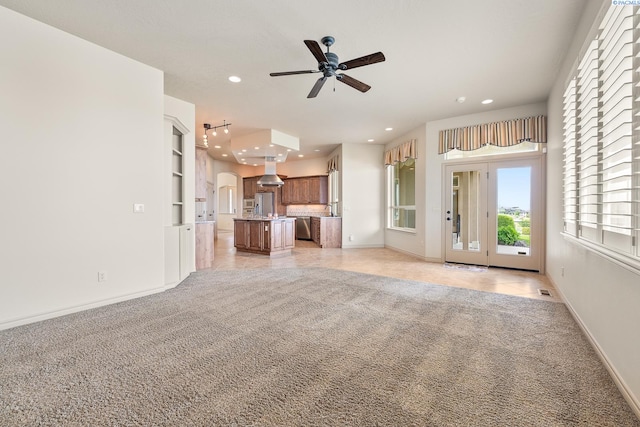 unfurnished living room with recessed lighting, ceiling fan, light colored carpet, and baseboards