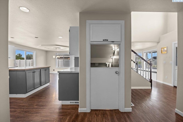 kitchen with dark wood finished floors, baseboards, light countertops, a textured ceiling, and recessed lighting