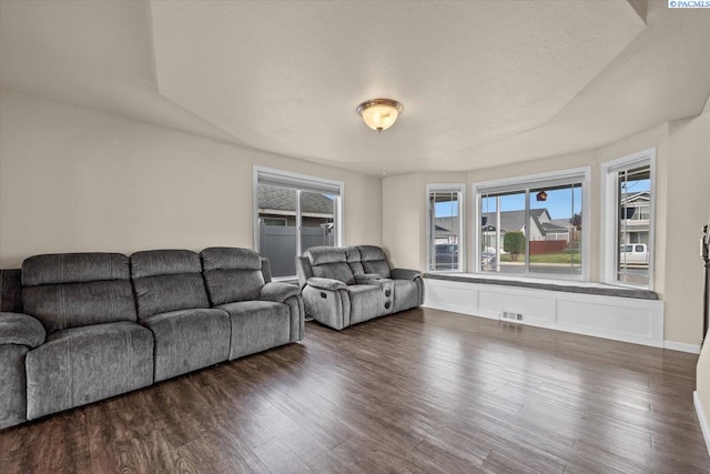 living room featuring wood finished floors, a textured ceiling, and baseboards