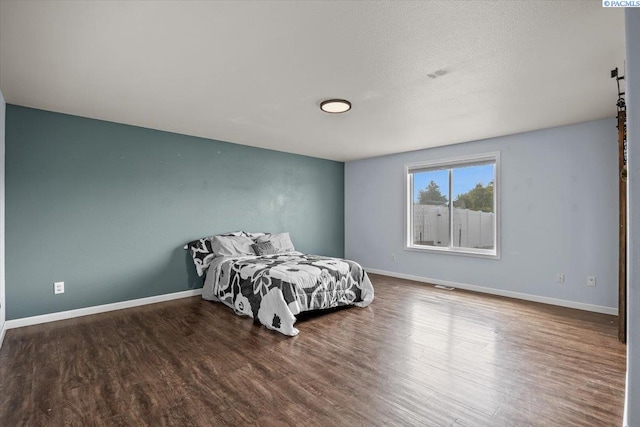 bedroom featuring wood finished floors and baseboards