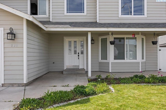property entrance featuring a porch and a lawn