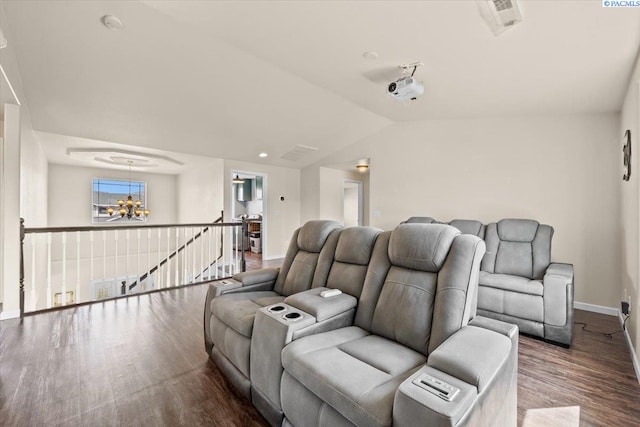 home theater with a chandelier, baseboards, wood finished floors, and lofted ceiling