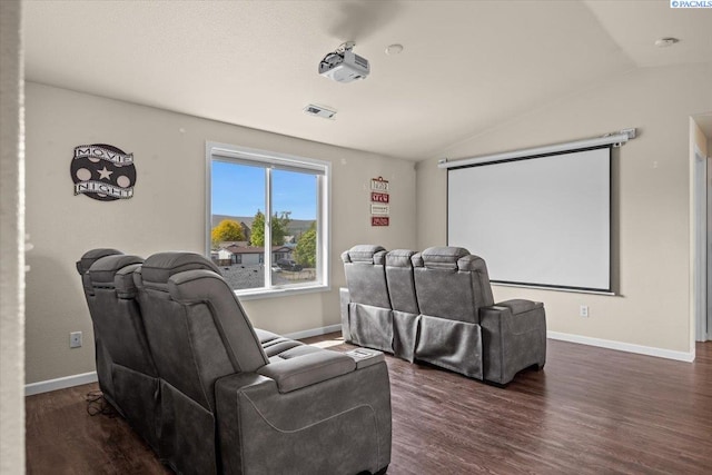 home theater room featuring vaulted ceiling, wood finished floors, and baseboards