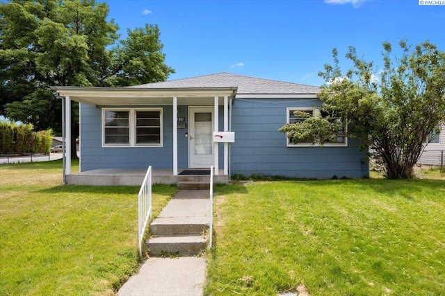 1001 Wilson St, Richland, WA 99354 - view of front of house featuring a front lawn, a porch, and roof with shingles