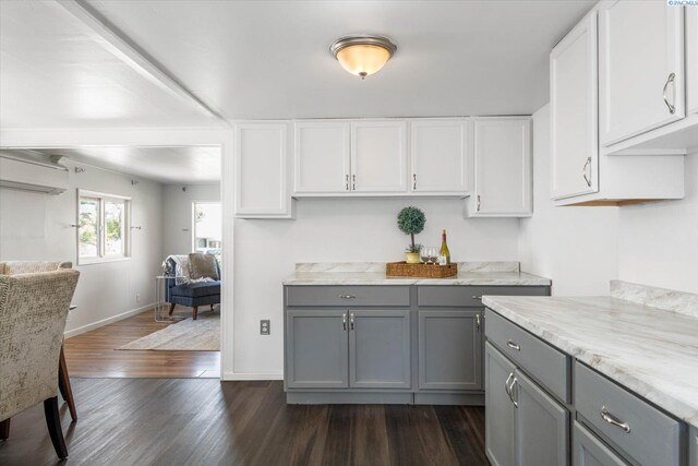 kitchen with a wall mounted AC, gray cabinetry, white cabinets, dark hardwood / wood-style flooring, and light stone countertops