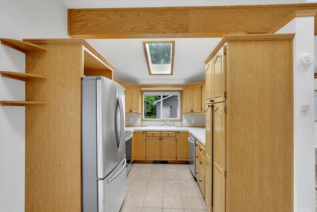 807 N Main St, Colfax, WA 99111 - kitchen featuring appliances with stainless steel finishes, light countertops, light brown cabinetry, light tile patterned flooring, and a sink