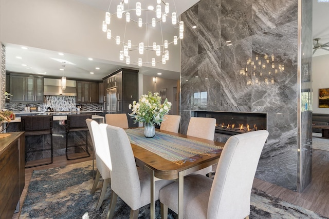 9115 W Maple Dr, Pasco, WA 99301 - dining area featuring a chandelier, recessed lighting, a premium fireplace, a high ceiling, and wood finished floors