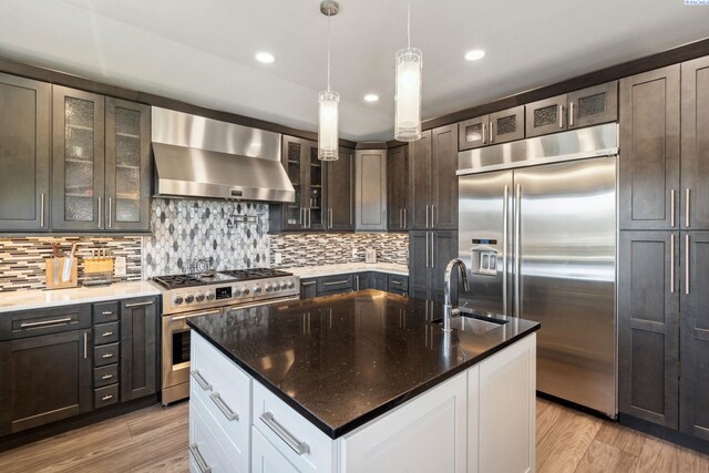 9115 W Maple Dr, Pasco, WA 99301 - kitchen with high quality appliances, exhaust hood, backsplash, a center island with sink, and recessed lighting