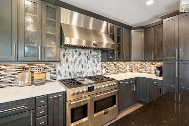 9115 W Maple Dr, Pasco, WA 99301 - kitchen featuring ventilation hood, range with two ovens, tasteful backsplash, glass insert cabinets, and light stone counters