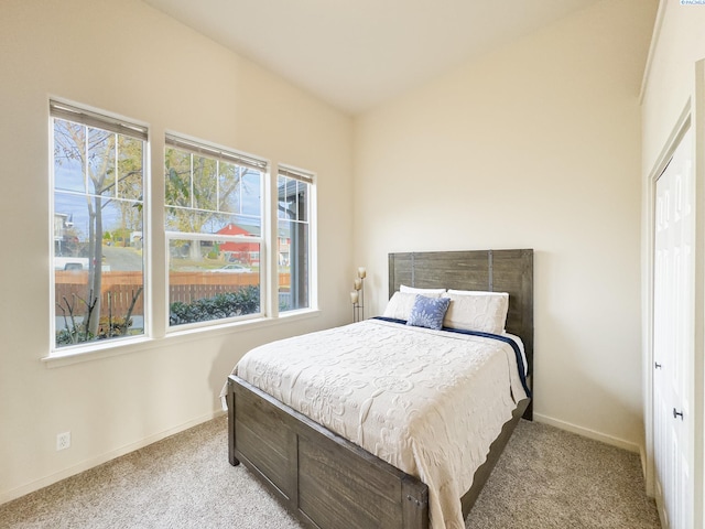 bedroom with light carpet and baseboards