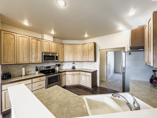 kitchen featuring decorative backsplash, stainless steel appliances, light brown cabinets, a sink, and recessed lighting