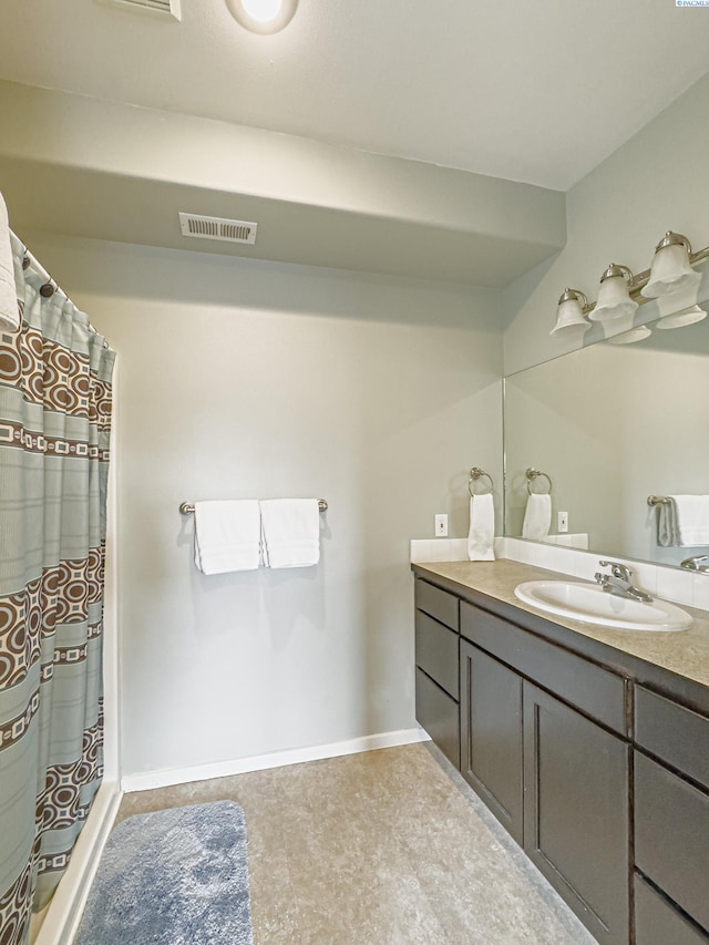 bathroom featuring visible vents, vanity, and baseboards