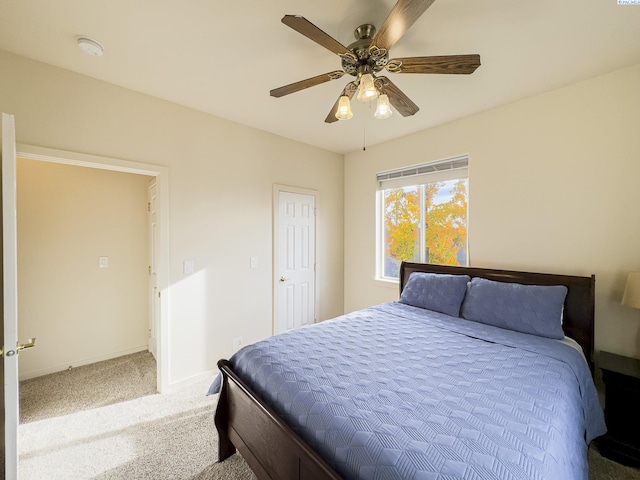 carpeted bedroom with ceiling fan and baseboards