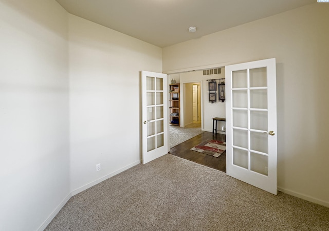 carpeted spare room with french doors, visible vents, and baseboards