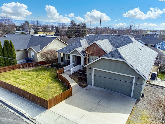 ranch-style house featuring a garage, driveway, roof with shingles, fence, and a front lawn