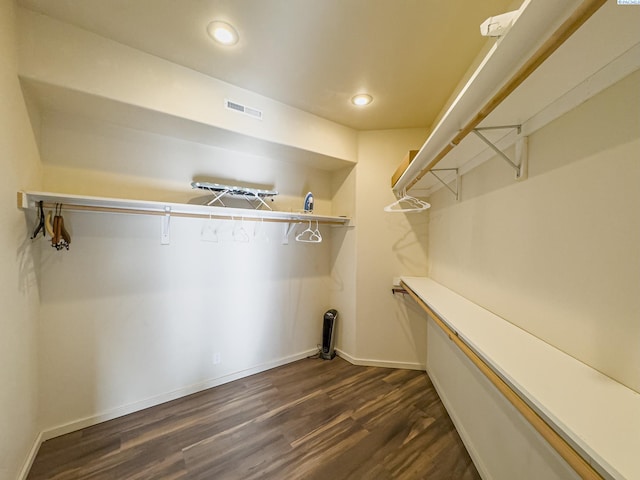 spacious closet featuring dark wood-type flooring and visible vents