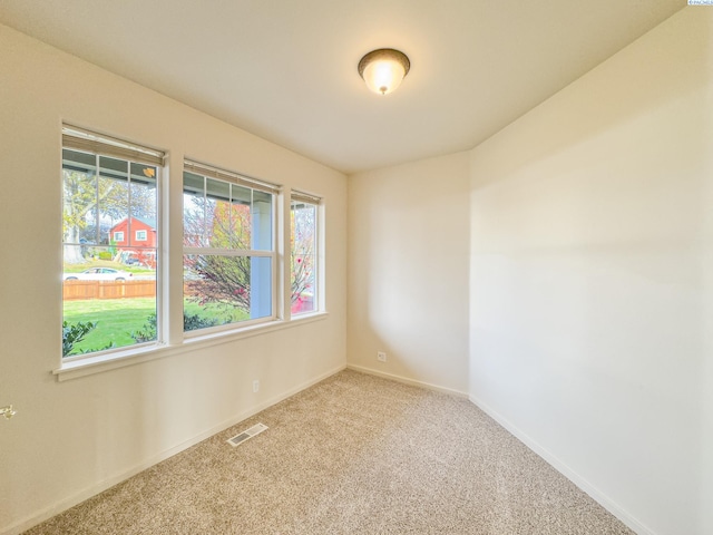 unfurnished room featuring carpet flooring, visible vents, and baseboards