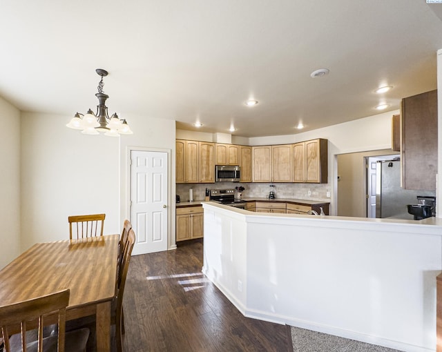 kitchen featuring decorative backsplash, dark wood-style floors, appliances with stainless steel finishes, a peninsula, and recessed lighting