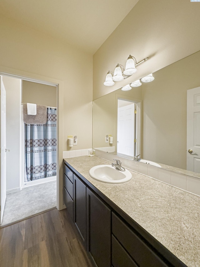 full bathroom featuring wood finished floors, vanity, and a shower with curtain