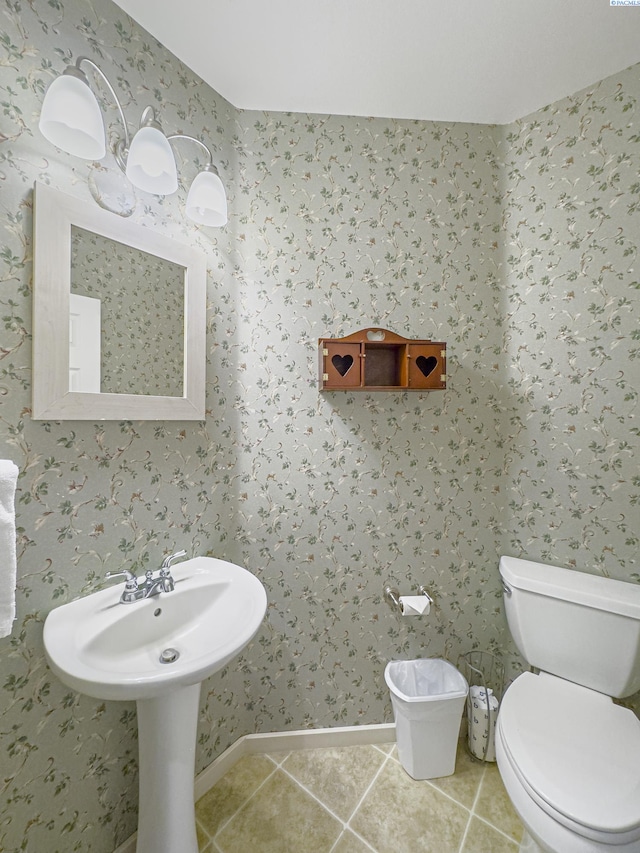 half bath featuring toilet, wallpapered walls, and tile patterned flooring