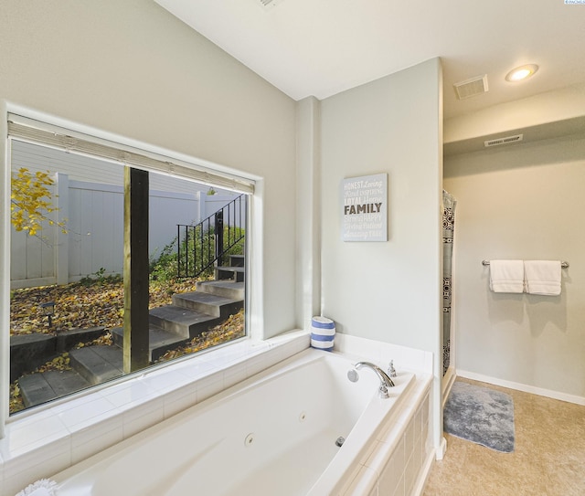 bathroom with baseboards, visible vents, a jetted tub, and a shower stall