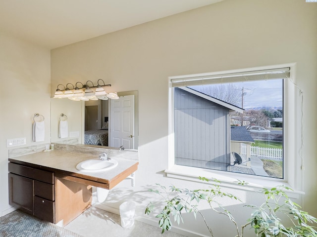 ensuite bathroom with connected bathroom and vanity