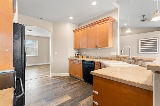 kitchen with hanging light fixtures, black appliances, lofted ceiling, dark hardwood / wood-style flooring, and sink