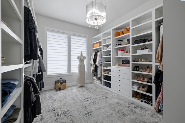 walk in closet with an inviting chandelier