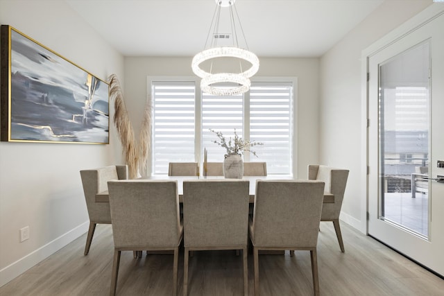 dining space featuring a notable chandelier and light hardwood / wood-style flooring