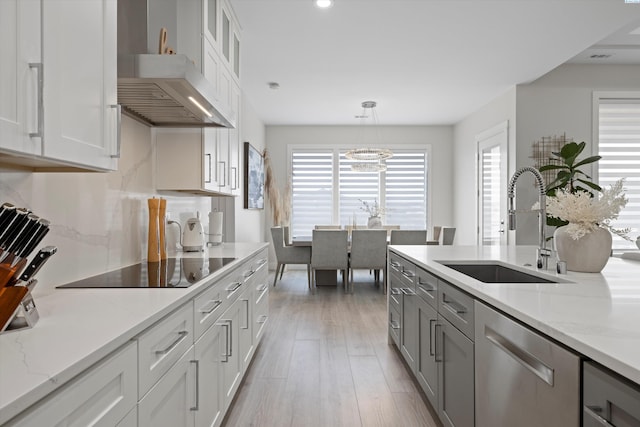 kitchen featuring white cabinetry, dishwasher, and hanging light fixtures