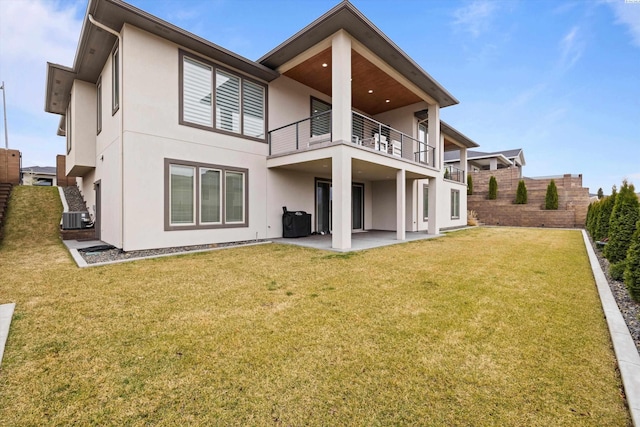 back of property featuring central AC unit, a patio area, a balcony, and a lawn