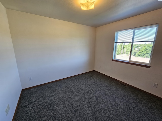 1135-1137 NE Indiana St, Pullman, WA 99163 - spare room featuring dark colored carpet, baseboards, and visible vents