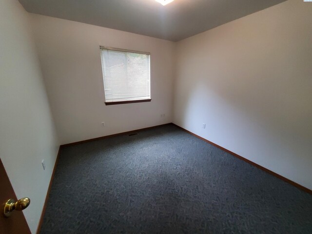 1135-1137 NE Indiana St, Pullman, WA 99163 - empty room featuring baseboards and dark colored carpet