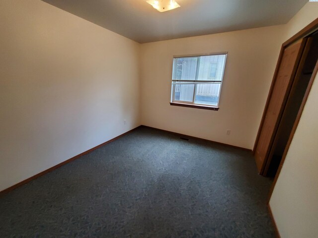 1135-1137 NE Indiana St, Pullman, WA 99163 - unfurnished bedroom with baseboards and dark colored carpet