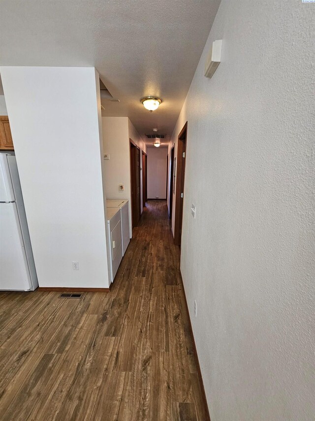 1135-1137 NE Indiana St, Pullman, WA 99163 - corridor with dark wood-style flooring, a textured wall, a textured ceiling, baseboards, and visible vents