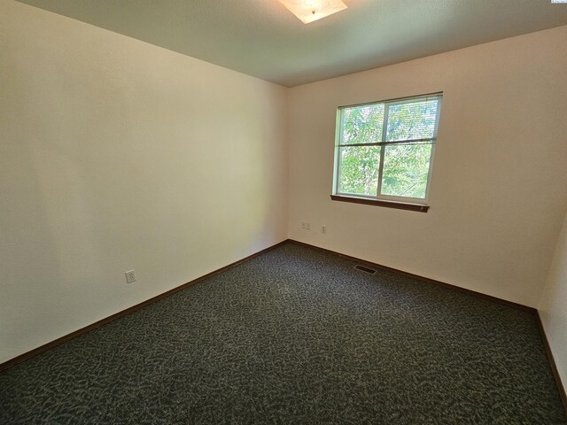 1135-1137 NE Indiana St, Pullman, WA 99163 - empty room featuring baseboards and dark carpet