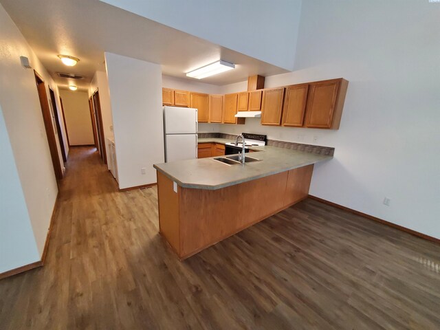 1135-1137 NE Indiana St, Pullman, WA 99163 - kitchen featuring a sink, baseboards, a peninsula, and white appliances