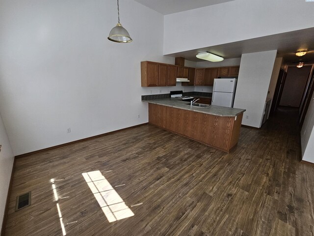 1135-1137 NE Indiana St, Pullman, WA 99163 - kitchen featuring visible vents, freestanding refrigerator, a peninsula, under cabinet range hood, and dark wood-type flooring
