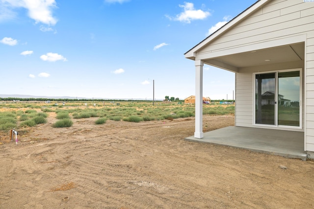 view of yard featuring a rural view and a patio area