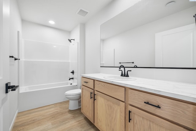 full bathroom featuring vanity, hardwood / wood-style flooring, bathing tub / shower combination, and toilet