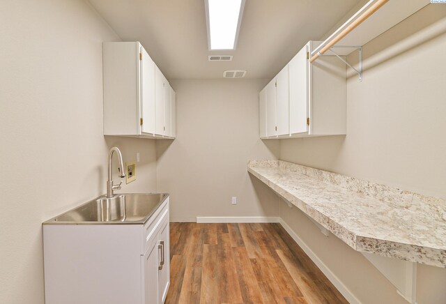 745 SE Carolstar Dr, Pullman, WA 99163 - laundry area with wood finished floors, hookup for a washing machine, baseboards, and cabinet space