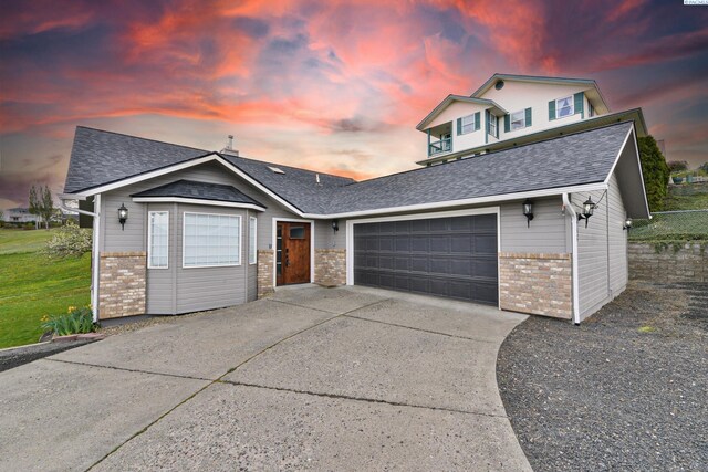 745 SE Carolstar Dr, Pullman, WA 99163 - view of front of house with brick siding, an attached garage, driveway, and roof with shingles