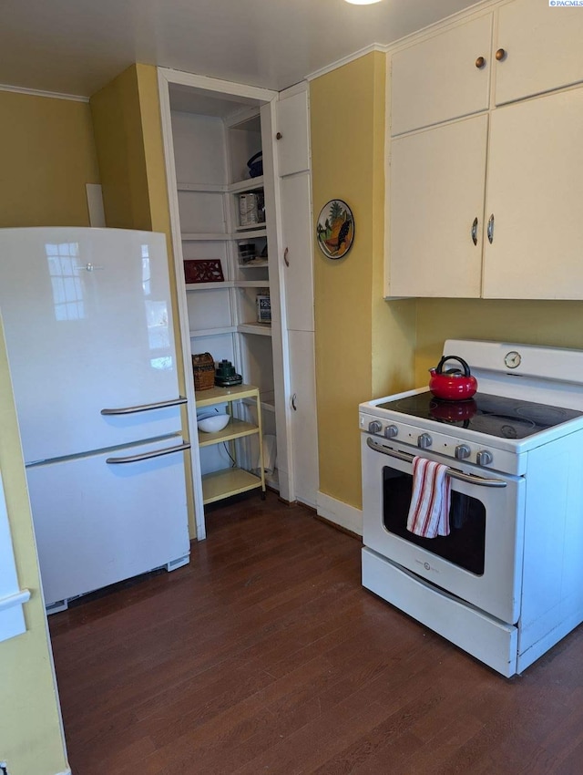 kitchen with dark wood-type flooring, white cabinets, and white appliances