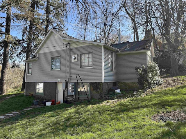 rear view of property featuring a lawn